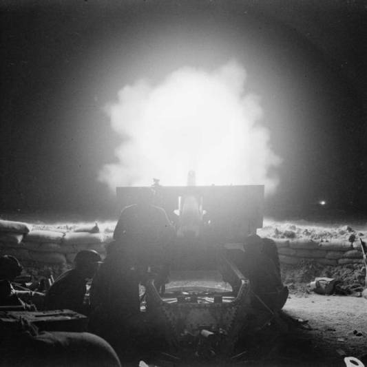 A QF 25 Pounder fires at night to support an infantry advance.