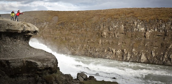 Two clowns dressed in yellow and red standing inches from death near a violent river on mighty Iceland! :)